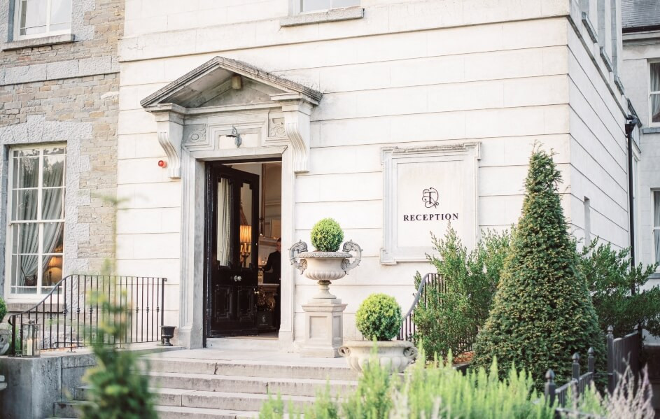 The Main House reception entrance with stone steps and a lit doorway.